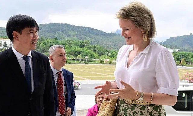 Queen Mathilde wore a printed maxi skirt by Nata, and white silk blouse. Queen Mathilde is making a 3-day working visit to Vietnam