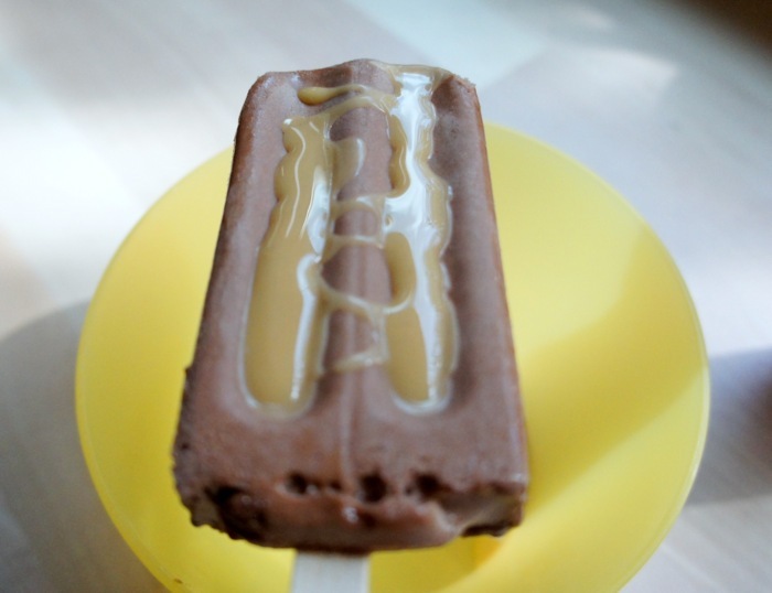 I drizzle some peanut butter shell topping into the grooves of the popsicle. Wait 15 seconds, and it's done!