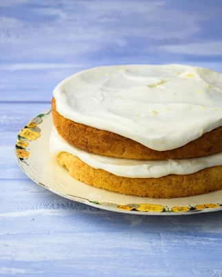 lemonade cake on cream plate, layered with frosting