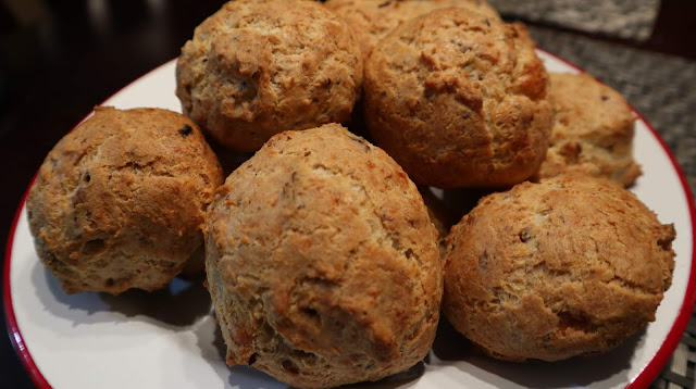 large sized Gougeres sitting on a white plate with a red rim