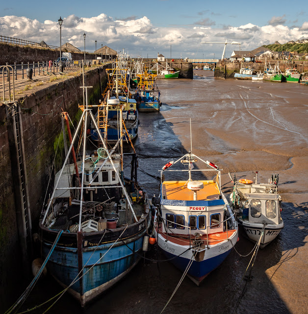 Photo of fishing boats sitting on the mud in Maryport Harbour