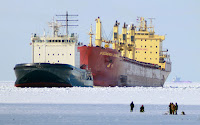 The Mudyug icebreaker, left, leads a ship named the Federal Danube as men fish in the frozen Gulf of Finland, some 25 miles west of St. Petersburg, Russia, Tuesday, March 15, 2011. (Credit: Dmitry Lovetsky / AP) Click to Enlarge.