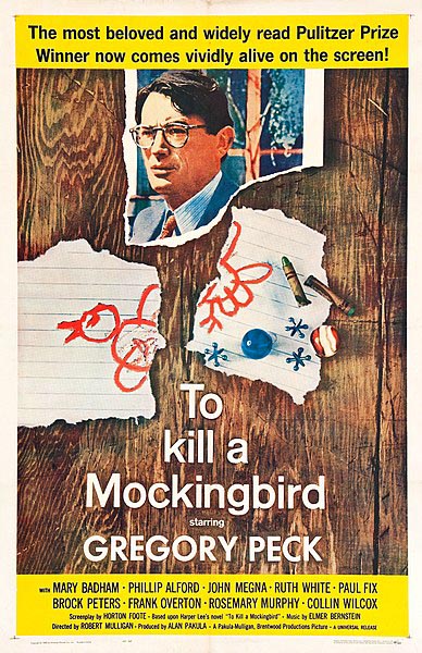 film poster with Gregory Peck as Atticus Finch, and a children's drawing of a bird on notebook paper torn in half, along with crayons and jacks, all seeming to be on a wooden floor