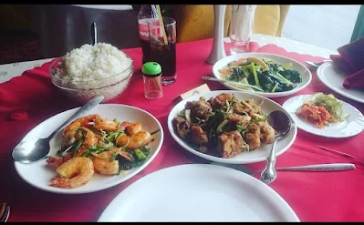 " Shrimp, rice,seafood tjapsoi,pepper, spicy fried squid and a cola laid out on the table at Chi Min restaurant in Paramaribo"