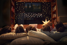 familia viendo película desde el sofá de su casa