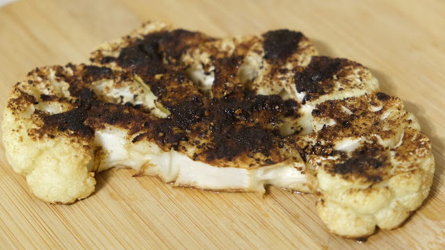 Fresh oven baked cauliflower stake on a chopping board