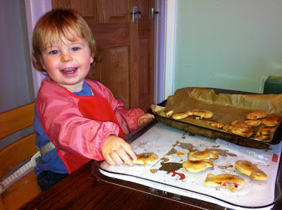 child smearing glitter glue on salt dough tree decorations