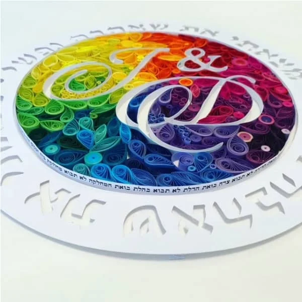 colorful, circular monogram encircled by Hebrew wording