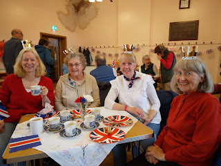 Four women seated at a table, enjoying coffee morning cakes