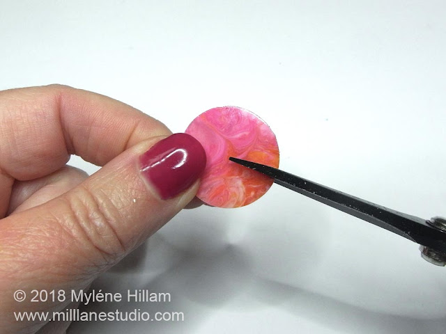 Cutting a slit into the resin from the edge to the centre.