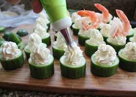 Food Lust People Love: Cheesy cucumber shrimp bites are a quick and easy cocktail party appetizer of fresh cucumber cups filled with spicy cheese and topped with beautiful boiled shrimp, their tails festively aloft.