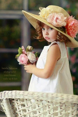 Foto gambar bayi perempuan dengan gaya busana feminim memakai topi cantik