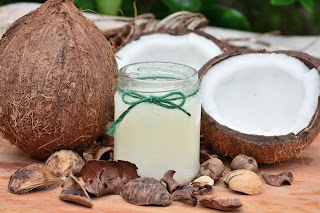 Open coconuts with coconut milk in a jar