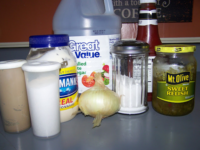 Salt and pepper, onion, jar of sweet pickles, bottles of vinegar, ketchup and mayonnaise on a counter