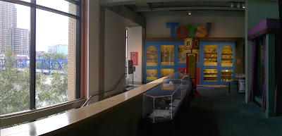 stitched panorama shows museum interior and scene through the large wall windows