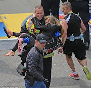 . by the crowd away from the scene of carnage, and this too has found its . (boston marathon carrying the injured )