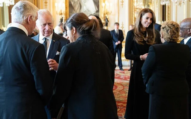 Queen Consort, the Prince and Princess of Wales. Kate Middleton wore a black midi dress with a pearl necklace