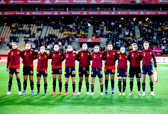 SELECCIÓN DE ESPAÑA FEMENINA. Temporada 2021-22. Jenni Hermoso, Alexia Putellas, Aitana Bonmati, Amaiur Sarriegi, Andrea Pereira, Patri Guijarro, Mariona Caldentey, Leila Ouahabi, Ona Batlle, Sandra Paños, Irene Paredes. Las jugadores españoles formadas para escuchar el himno nacional. SELECCIÓN DE ESPAÑA FEMENINA 8 SELECCIÓN DE ESCOCIA FEMENINA 0 Martes 30/11/2021, 21: 00 horas. Copa del Mundo Femenina Australia y Nueva Zelanda 2023, fase de clasificación, Grupo B de la zona europea, 5ª jornada. Sevilla, estadio de La Cartuja: 1.000 espectadores. Entrenadores: España: Jorge Vilda. Escocia: Pedro Martínez Losa. Árbitra: Lina Lehtovaara (Finlandia). GOLES: 1-0: 20’, Amaiur Sarriegi. 2-0: 33’, Mariona Caldentey. 3-0: 41’, Aitana Bonmati. 4-0: 58’, Amaiur Sarriegi. 5-0: 61’, Aitana Bonmati. 6-0; 64’, Alexia Putellas. 7-0: 80’, Jennifer Hermoso. 8-0: 83’, Esther González.