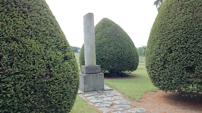 Stèle en colonne au bout de l'allée du jardin du souvenir