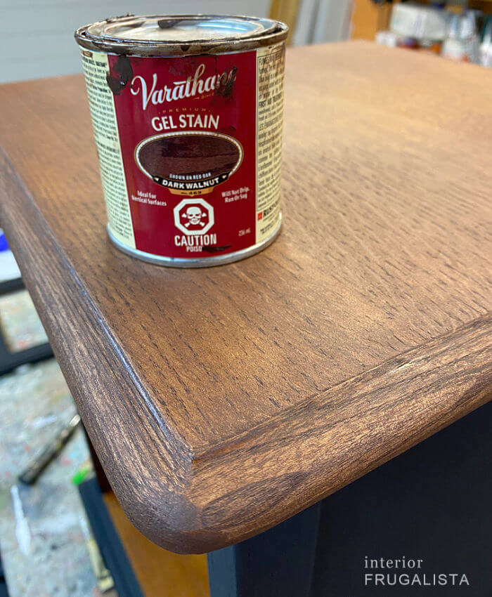 A black painted end table makeover with dark walnut gel stained top.