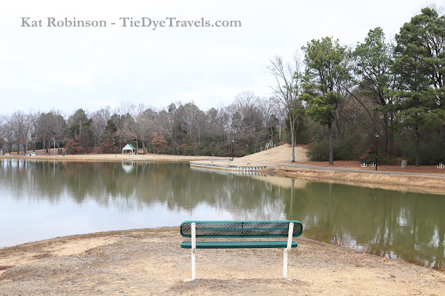 A bench alongside a pond at Olive Branch City Park in Olive Branch, MS.