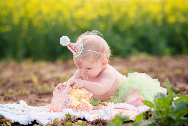 Family session including one-year cake smash in an Oklahoma canola field by Michelle Valantine Photography.