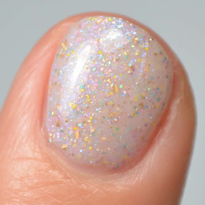 off white nail polish with sparkles and color shifting flakies swatch close up