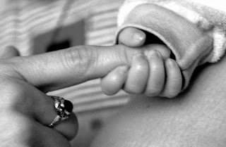 Image: Newborn holding mom's finger, by mvictor on MorgueFile
