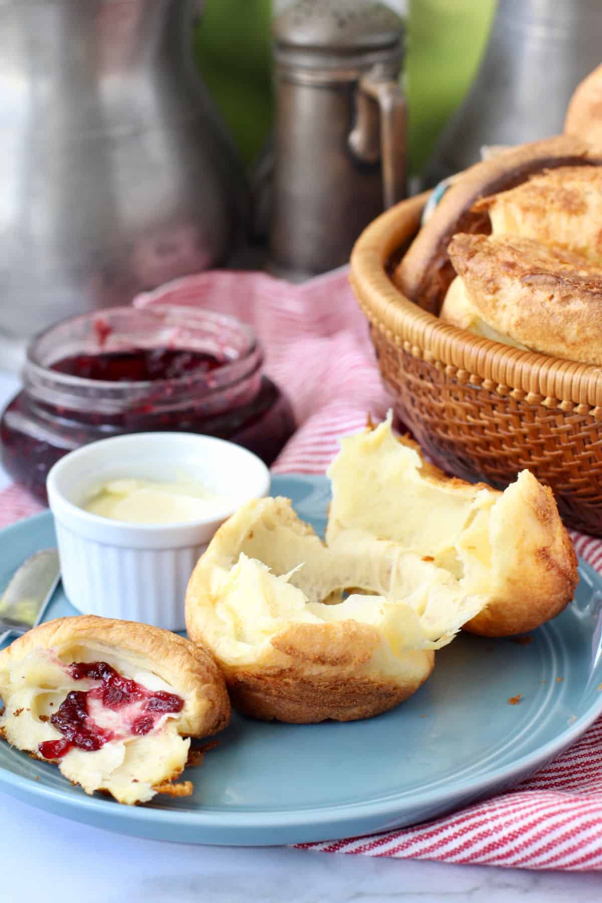 Homemade popovers with butter and jam on a blue plate.