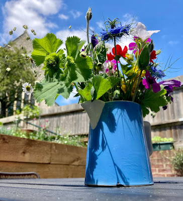 Pretty flowers in a blue jug with a church in the background