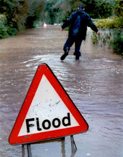 man wading through floods