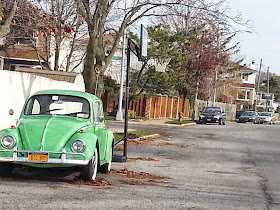 A green Volkswagen Bug parked on a side street in Staten Island