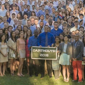 A color photograph of a smiling crowd of people, two holding up a sign reading "Dartmouth 2016."