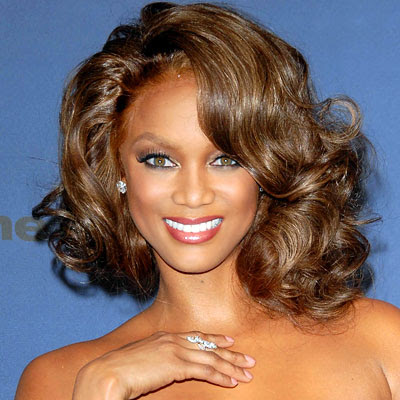Tyra Banks favors long hair styles and combines them with braids and hair 