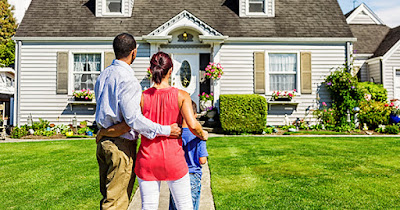 Low income couple in front of their home