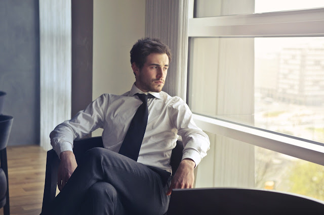 Young business man looking out window, personal development