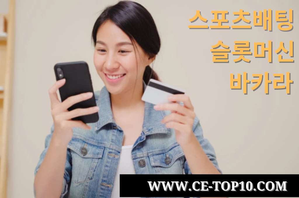 Beautiful young lady holding a mobile phone and credit card.