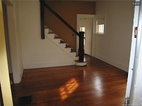 living room and staircase of yellow house for sale at 70 Crescent Street, Winsted, CT