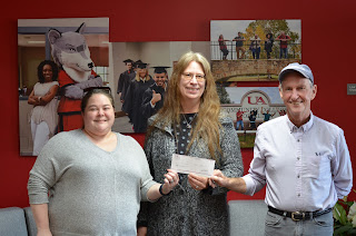 Kimberly Hulit, NTHS President and business student, and Tom McLeod, NTHS advisor and faculty member, present Elizabeth Luscombe of Conway County Literacy Council with a charitable donation. Elizabeth is also a student at UACCM.