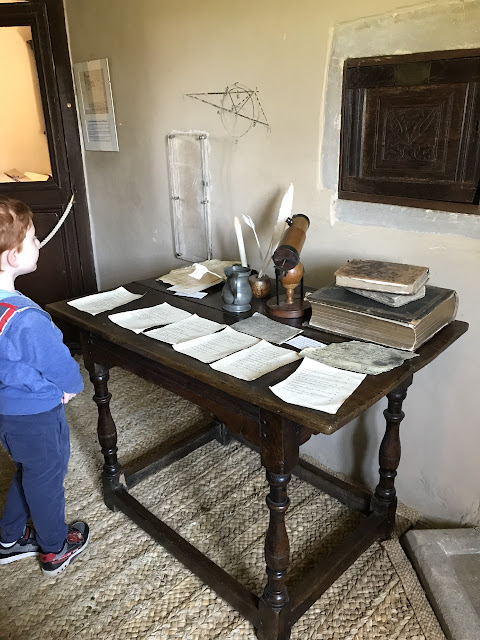 Little boy looking at an edwardian desk covered in papers and books