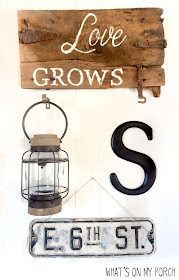 gallery wall with love grows wood sign, monogram letter, street sign and lantern