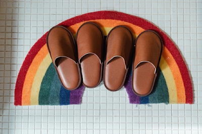 Two Pair of Leather Slippers and Rainbow Background