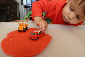 Child playing with a car in play dough