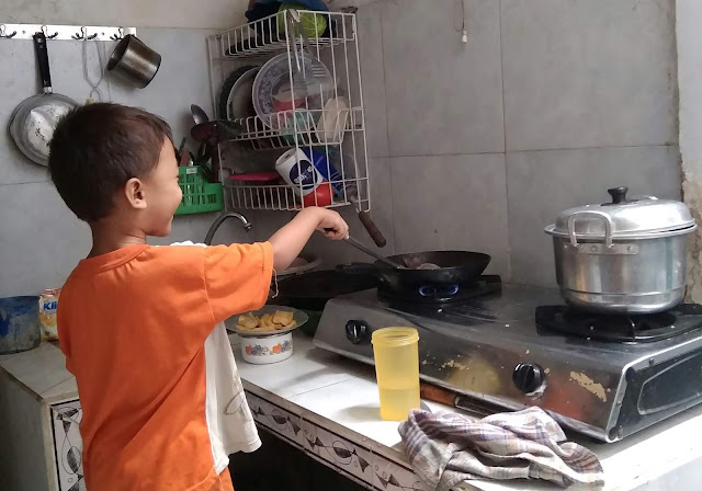 Mengajari anak membantu orang tua memasak di dapur