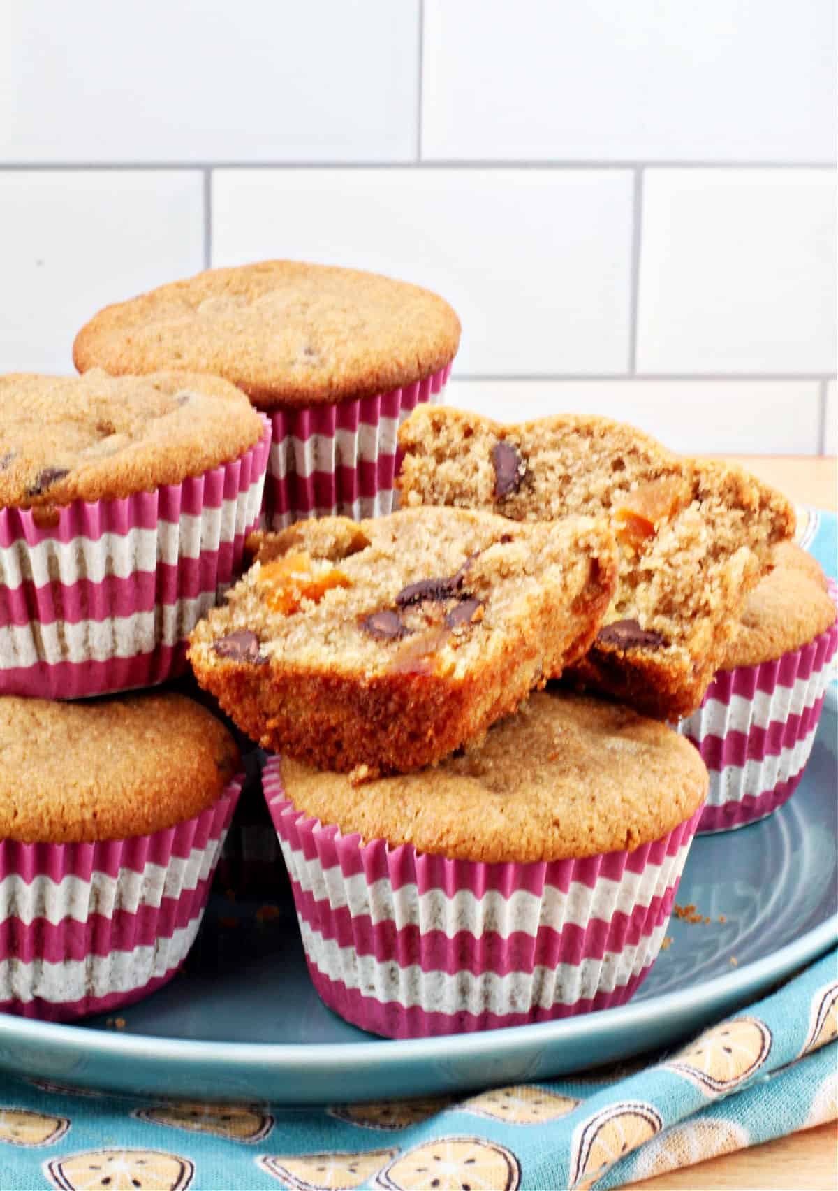 Tahini and Coconut Muffins on a blue plate with one muffin cut in half.