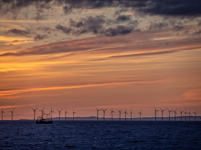 A photo of a fishing boat passing Robin Rigg wind farm in the Solway Firth on its way home to Maryport