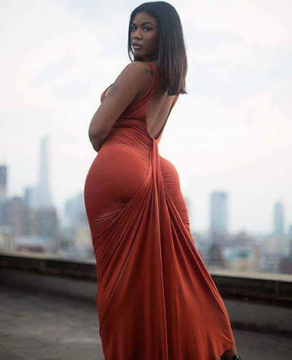 Black beautiful woman with erotic curves in tight dress wrapped around curves.