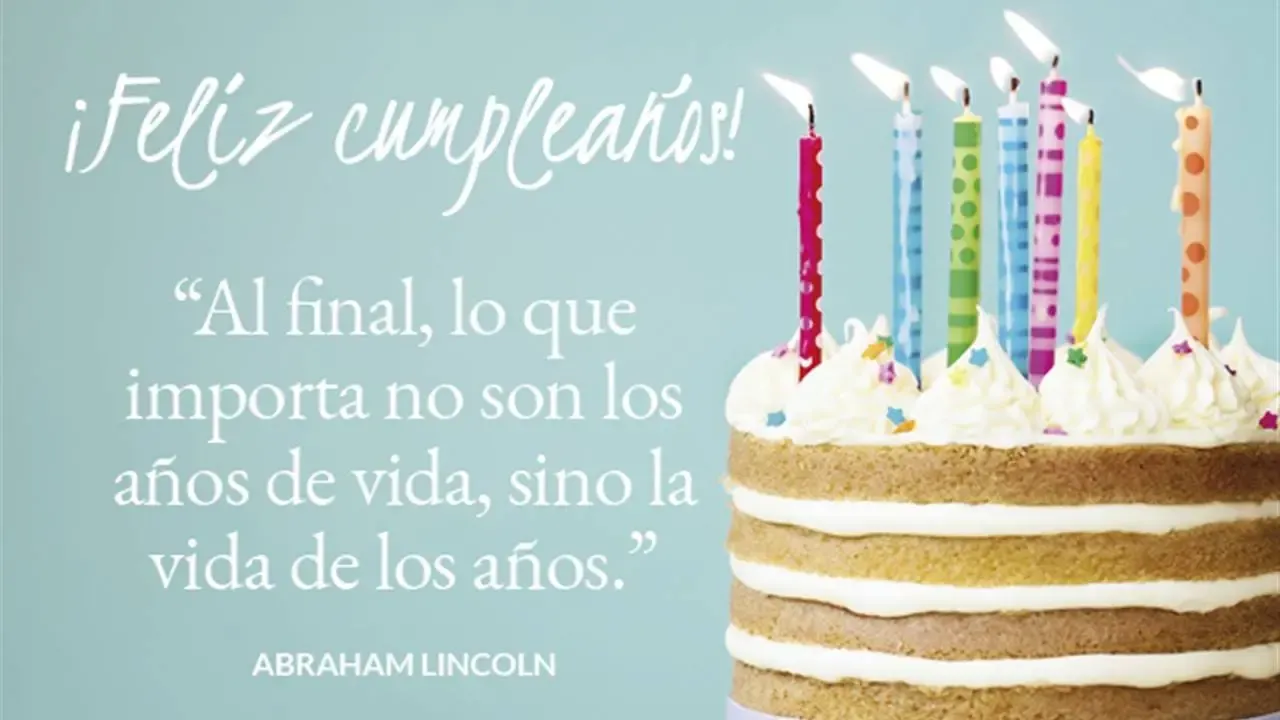 Pastel de cumpleaños colorido con velas encendidas y el texto en español "¡Feliz cumpleaños!"