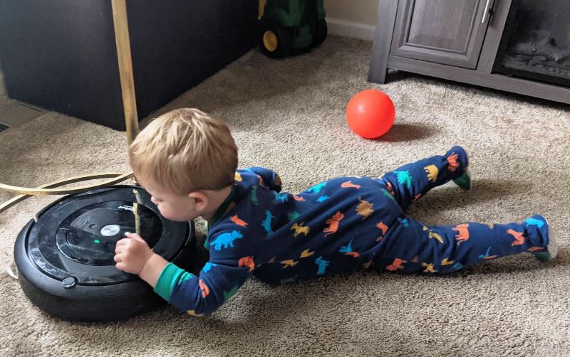 Montessori toddlers. Maximum Effort. Child with vacuum