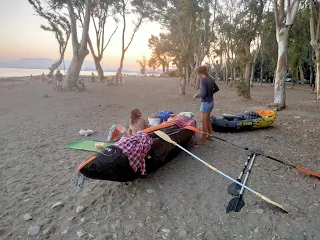 Our sleeping stuff on a beach at dusk, big trees